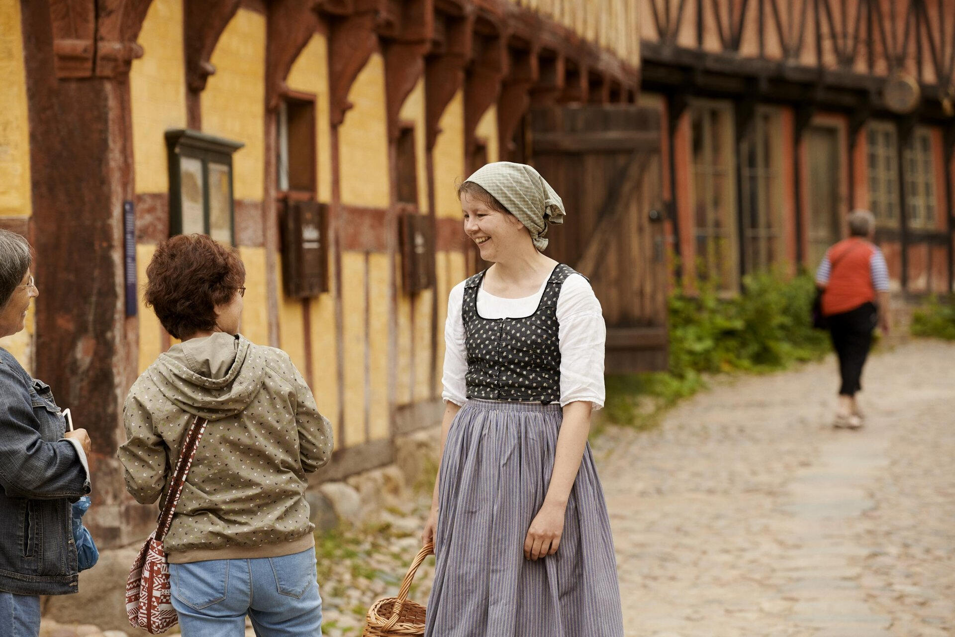 Den Gamle By (Photographer: Robin Skjoldborg) Guests walking through cobbled streets of Aarhus Old Town